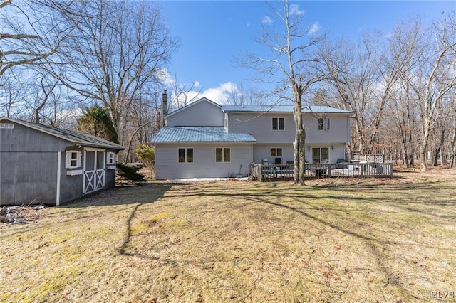 rear view of property with a storage shed, a lawn, and a deck