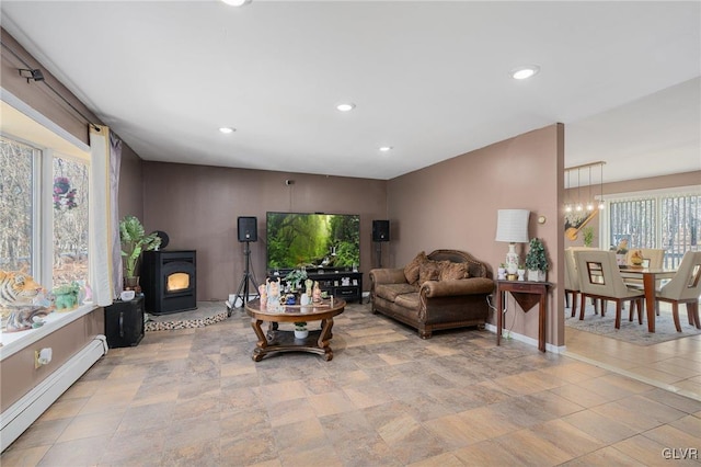 living room with a chandelier, a baseboard radiator, and a wood stove