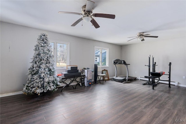 workout room with baseboard heating, ceiling fan, and dark hardwood / wood-style floors