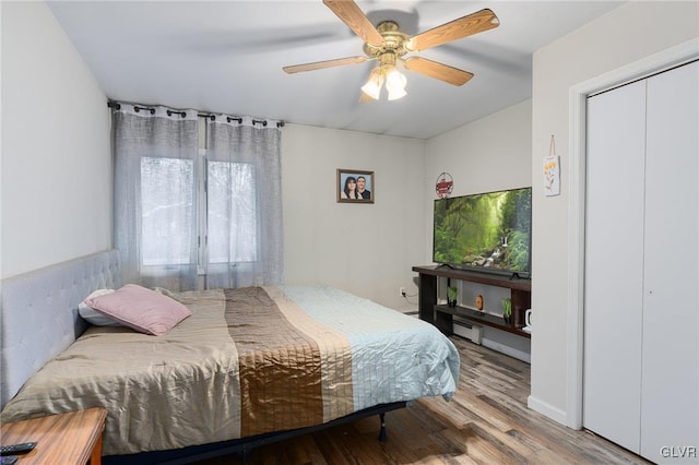 bedroom featuring ceiling fan, wood-type flooring, and a closet