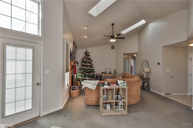 living room with carpet flooring, ceiling fan, high vaulted ceiling, and a skylight