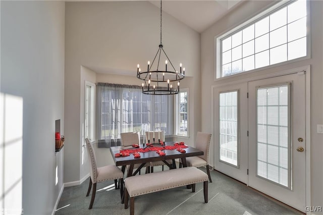 dining room with a towering ceiling, carpet, and a chandelier