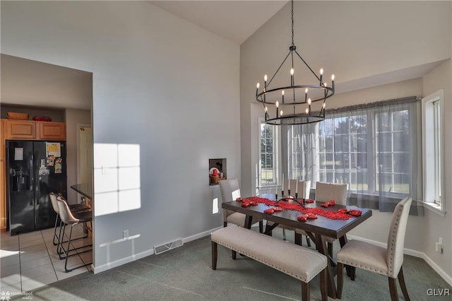 carpeted dining room with an inviting chandelier