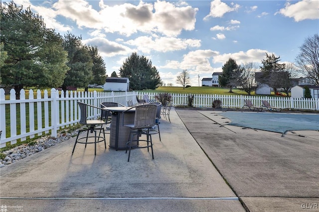 view of patio featuring a bar and a covered pool