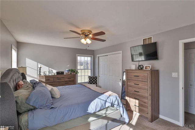 carpeted bedroom with ceiling fan and a closet