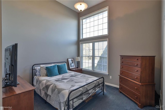 bedroom with multiple windows, dark carpet, and lofted ceiling