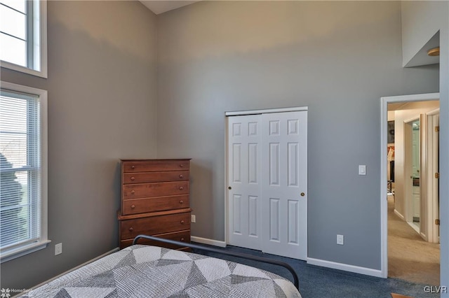 bedroom with a towering ceiling, a closet, and carpet floors