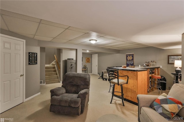 carpeted living room featuring bar and a paneled ceiling