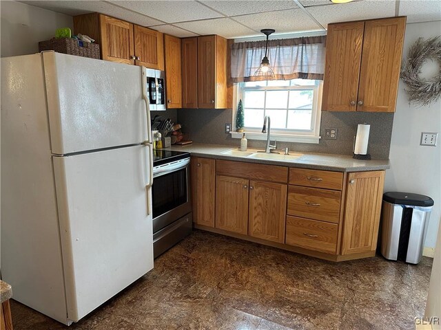 kitchen featuring hanging light fixtures, sink, a drop ceiling, and appliances with stainless steel finishes