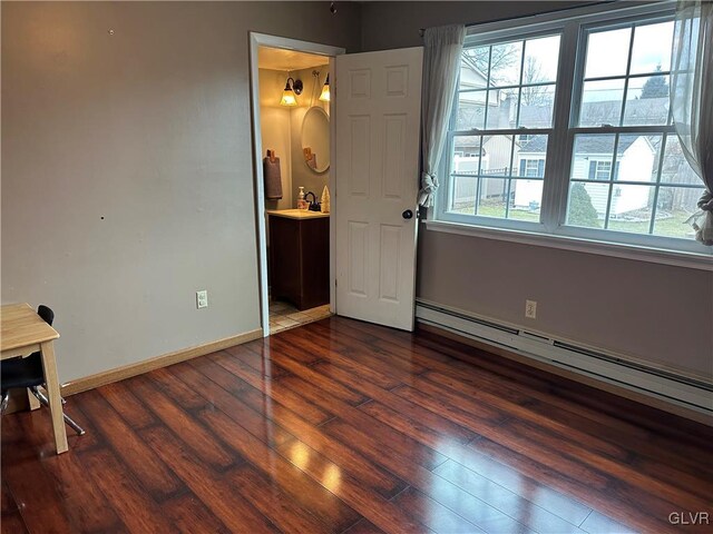 unfurnished bedroom featuring connected bathroom, a baseboard radiator, and dark wood-type flooring