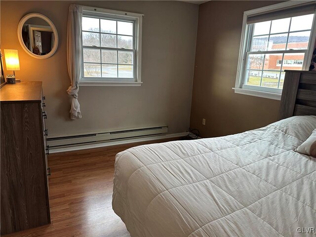 bedroom featuring hardwood / wood-style flooring and a baseboard radiator