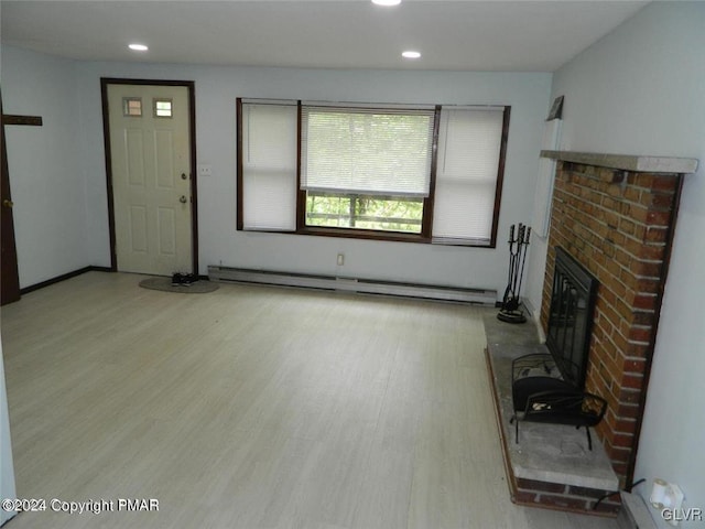 unfurnished living room with baseboard heating, light hardwood / wood-style flooring, and a brick fireplace