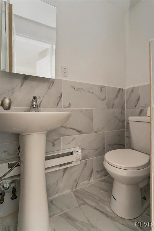 bathroom featuring tile walls and toilet