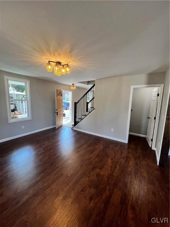 spare room with a healthy amount of sunlight and dark wood-type flooring