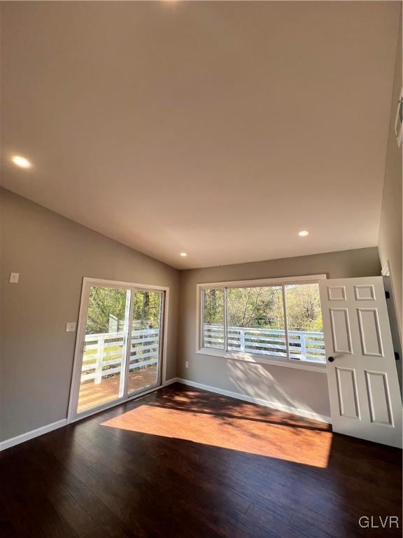 spare room with dark hardwood / wood-style floors and lofted ceiling