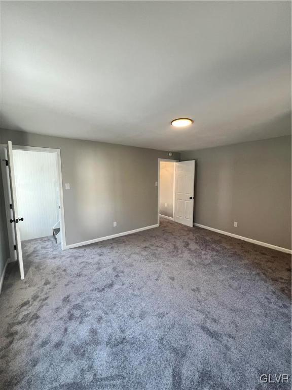 unfurnished room with dark colored carpet