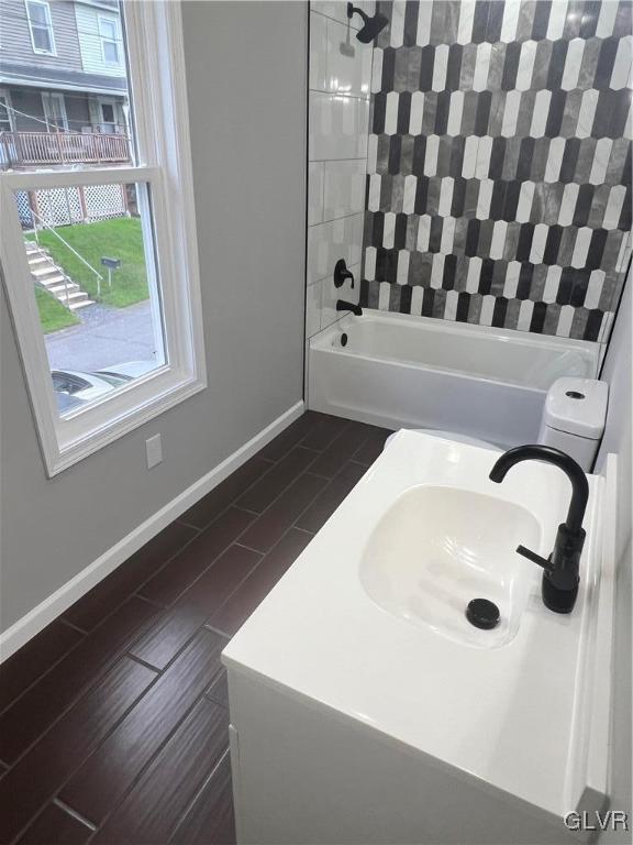 bathroom featuring tiled shower / bath combo and sink