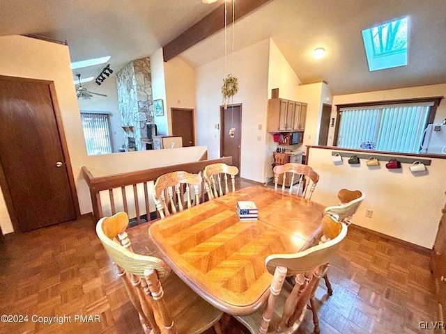 dining room featuring dark parquet flooring, lofted ceiling with skylight, and a stone fireplace