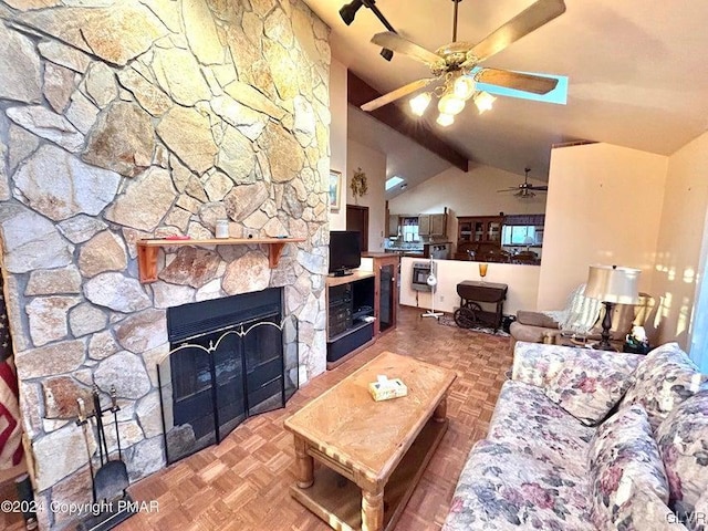 living room featuring vaulted ceiling with beams, a stone fireplace, and parquet floors