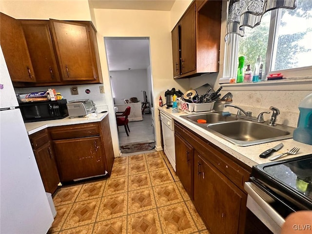 kitchen featuring white dishwasher, electric stove, and sink