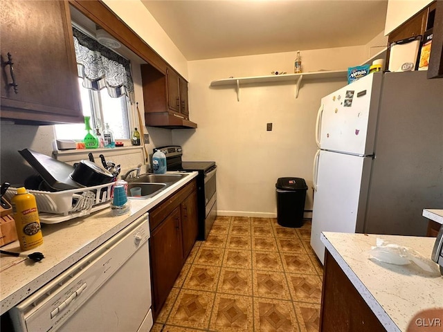 kitchen with dark brown cabinets, white appliances, and sink