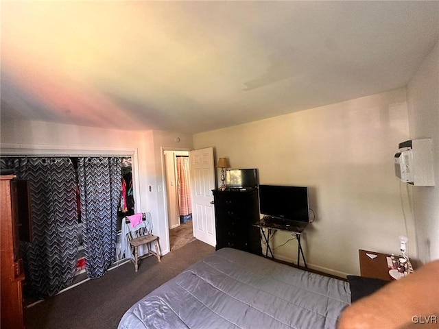 bedroom with a wall mounted AC, a closet, and dark carpet