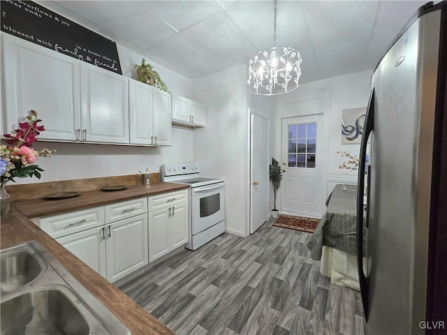 kitchen featuring stainless steel fridge, white cabinets, white electric range, butcher block countertops, and hanging light fixtures