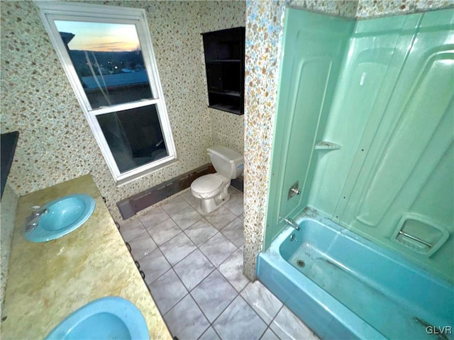 full bathroom with vanity, tile patterned floors, washtub / shower combination, and toilet