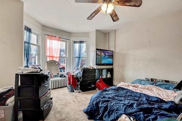 bedroom with carpet, ceiling fan, and radiator