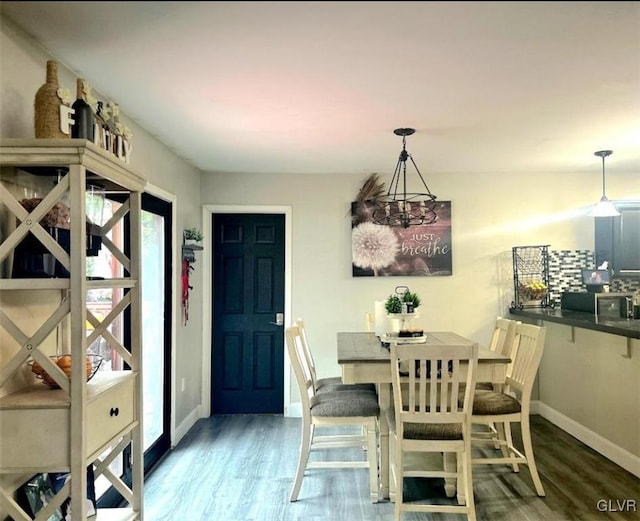 dining area featuring a notable chandelier and dark wood-type flooring