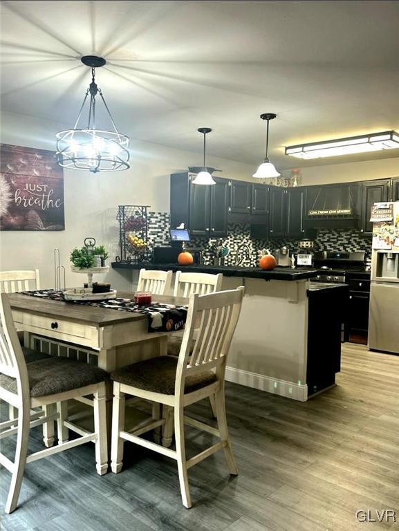 dining area with hardwood / wood-style flooring and a notable chandelier