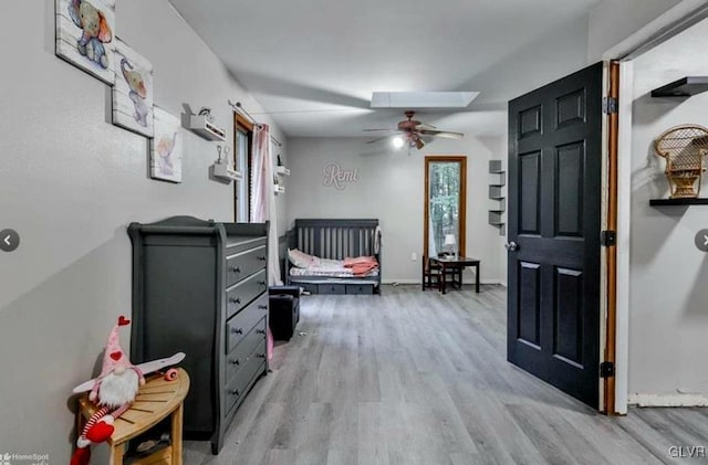 bedroom featuring a skylight and light hardwood / wood-style floors