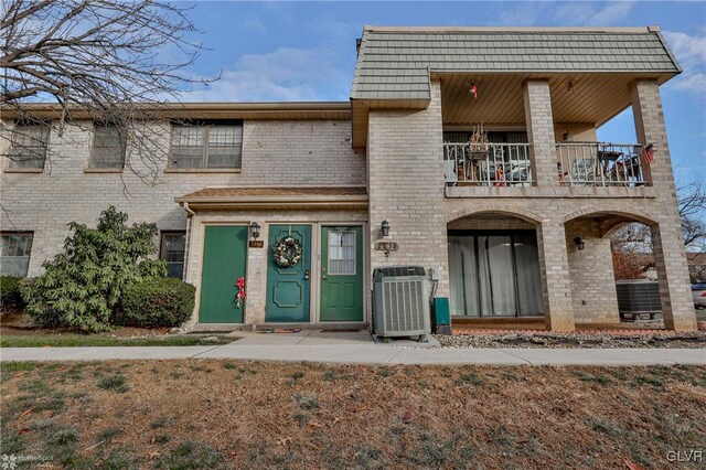 view of front of property with a balcony and central AC