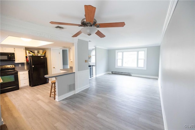 kitchen with ornamental molding, black appliances, a breakfast bar, and baseboard heating