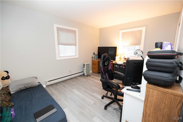 home office with light hardwood / wood-style flooring and baseboard heating