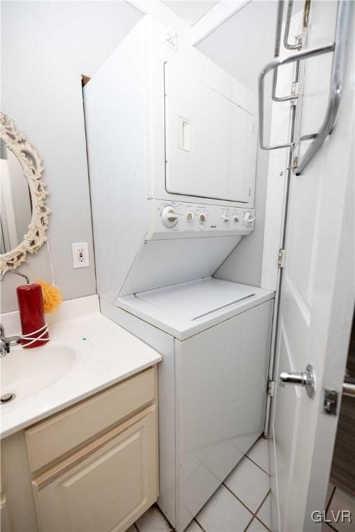 laundry room featuring stacked washer and clothes dryer, sink, and light tile patterned floors