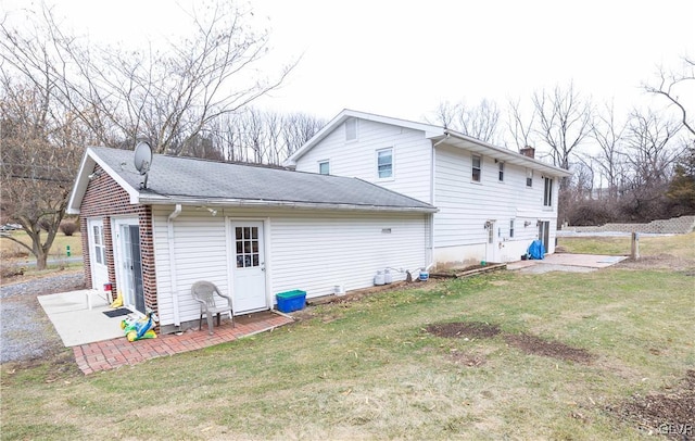 back of property with a garage and a lawn