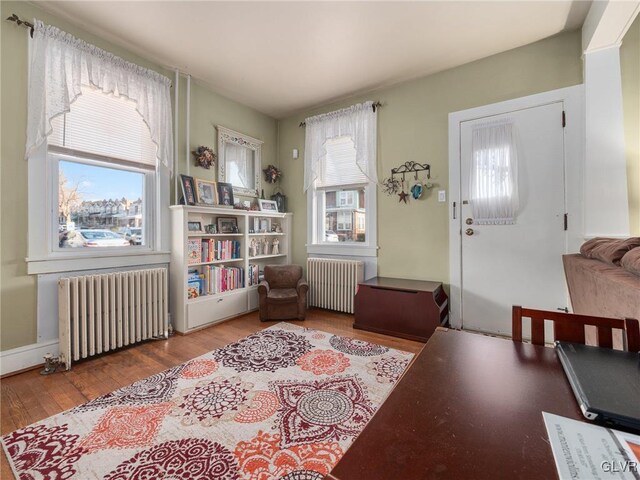 interior space featuring hardwood / wood-style flooring, radiator heating unit, and a wealth of natural light