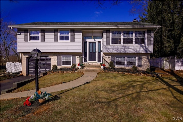 raised ranch featuring a front yard and a garage