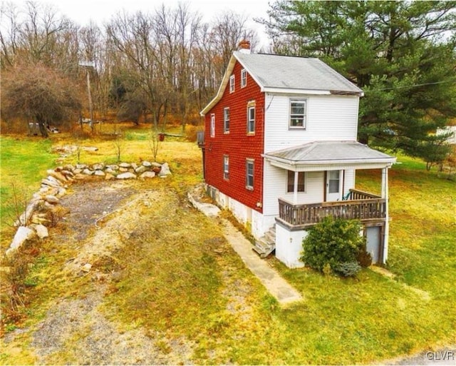 view of side of home with a lawn and covered porch