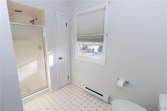 bathroom featuring toilet, a shower with door, and a baseboard heating unit