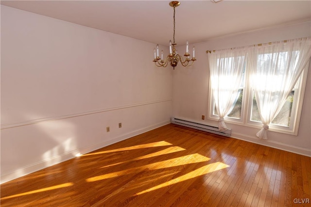 unfurnished room featuring hardwood / wood-style flooring, a chandelier, a wealth of natural light, and a baseboard heating unit