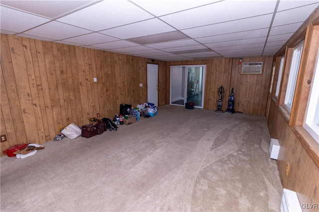 spare room featuring carpet flooring, a baseboard radiator, and wood walls