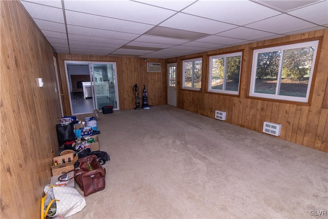 interior space with an AC wall unit, wooden walls, and carpet