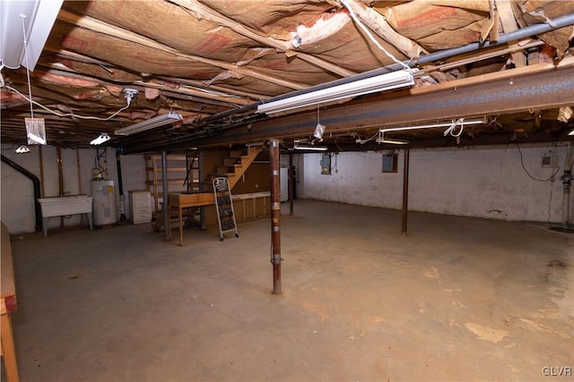 basement featuring electric panel, sink, gas water heater, and water heater