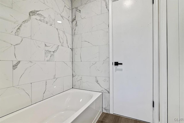 bathroom featuring hardwood / wood-style flooring and tiled shower / bath