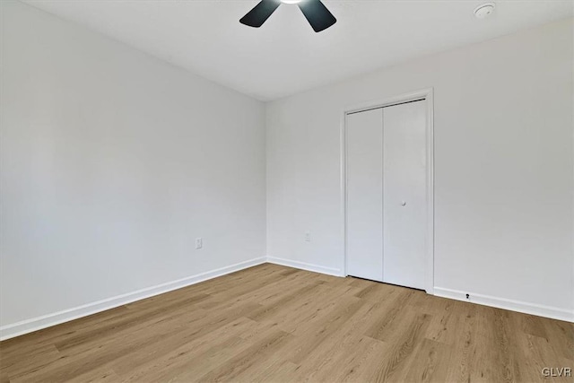 unfurnished bedroom featuring ceiling fan, light hardwood / wood-style floors, and a closet