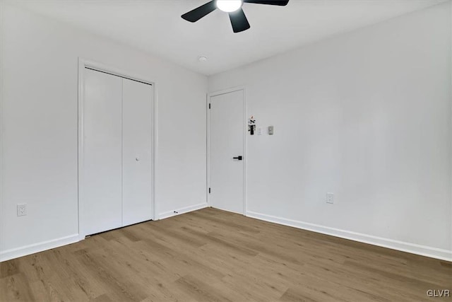 unfurnished bedroom featuring ceiling fan, a closet, and light hardwood / wood-style floors