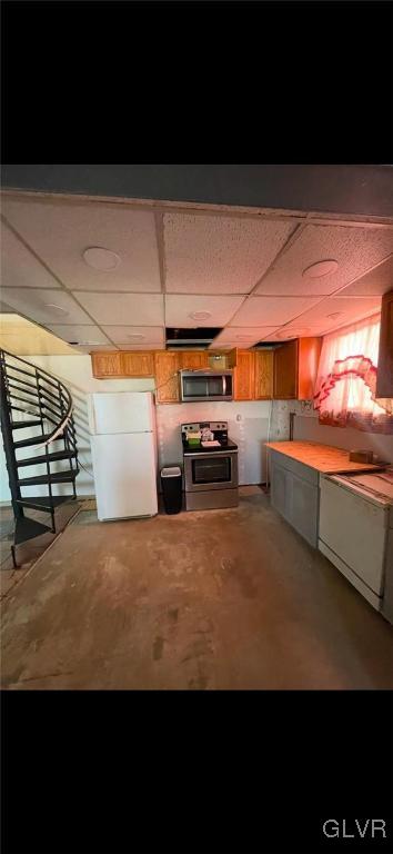 basement featuring white fridge and a drop ceiling