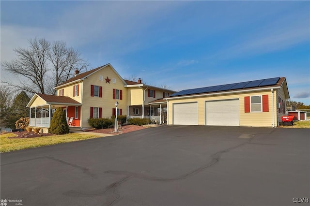 view of front property featuring solar panels and a garage